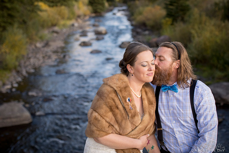 Bride and Groom kiss along the riverside in Minturn, CO