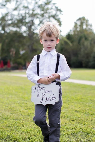 The ring bearer's sign says Here comes the Bride