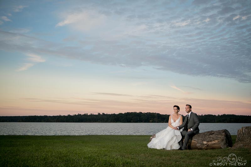 Bride and Groom sit beside Lake Oconee during glorious sunset