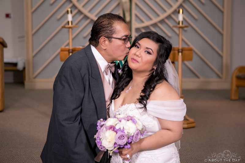 Father kisses bride and the cheek