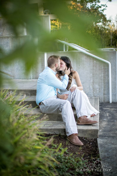 Eric & Ami kissing on cement steps at the Bremerton Marina