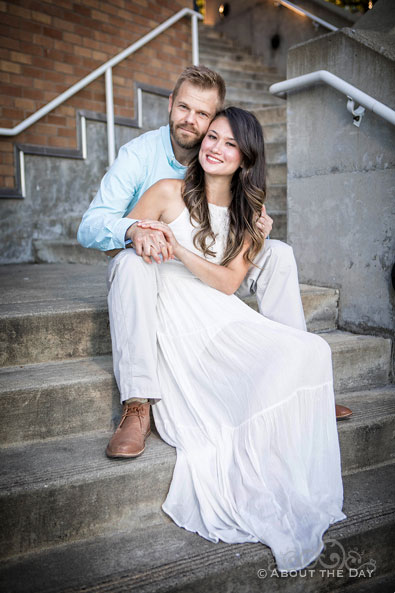 Eric & Ami sunggle on cement steps at the Bremerton Marina