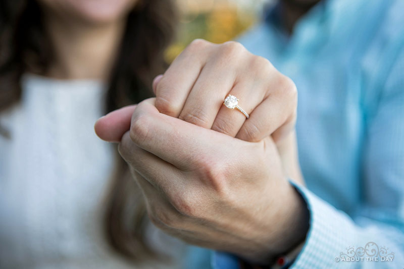 Engaged couple show her ring up close