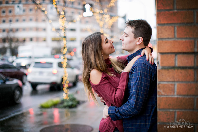 Will & Madelyn cuddle online the rainy street in Bellevue