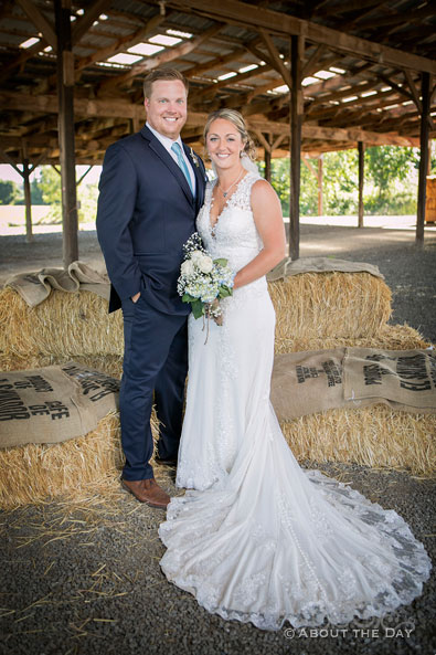 The Bride and Groom pose standing in the hay barn at Heiser Farms