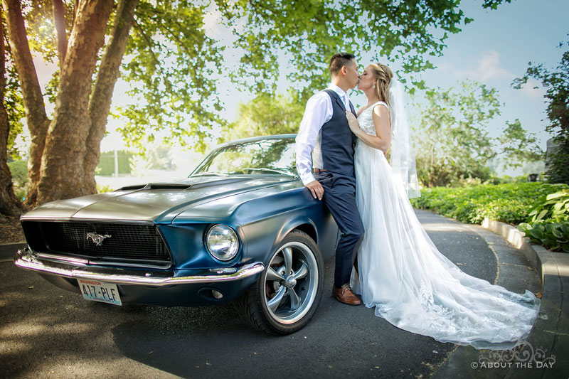 Douglas and Courtney kiss in front of their Mustang
