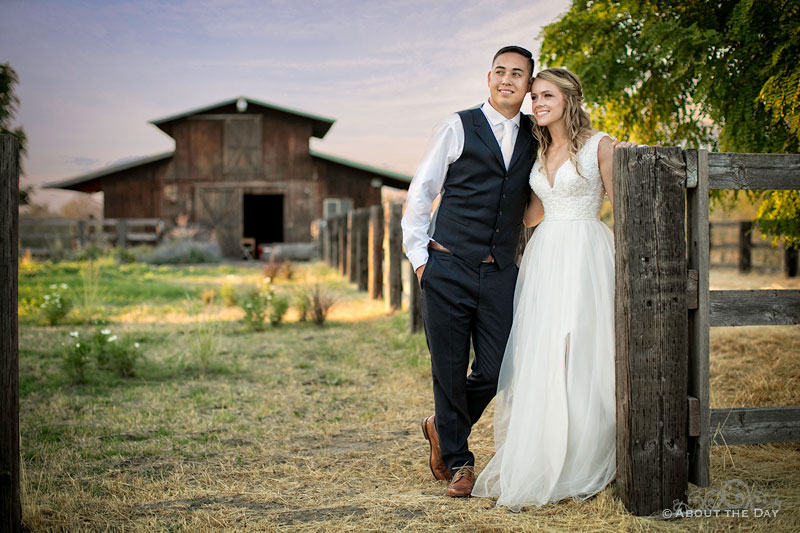 Courtney and Douglas pose with an old wooden barn in the background