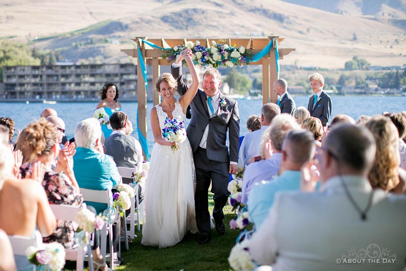 Bride and Groom exit wedding ceremony at Campbell's Resort at Lake Chelan