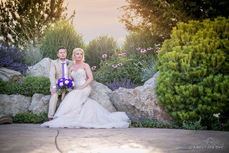 The Bride and Groom sit in the beautiful wedding site at Karma Vineyards