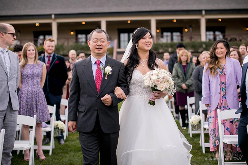 Eugenia's and her father walk down the isle at Zenith Vineyards