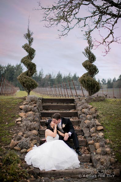 Bride and Groom kiss on stone steps at Zenith Vineyards
