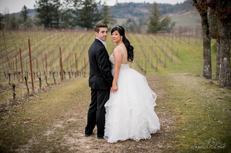 Bride and Groom stand in the vineyard at Zenith Vineyards