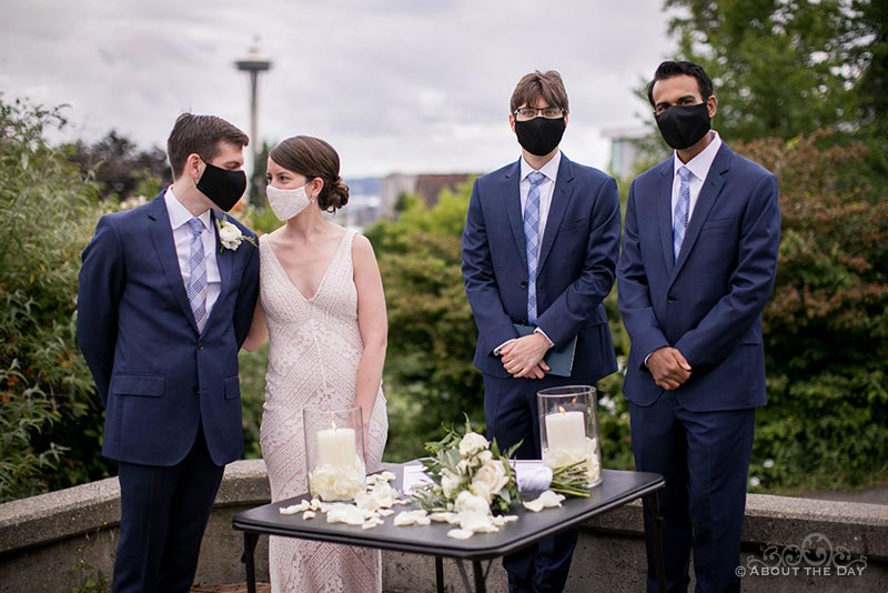 David & Vanessa and their wedding party in Bhy Kracke Park with a view of the Seattle skyliner