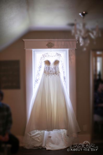 Courtney's wedding dress hangs in the window